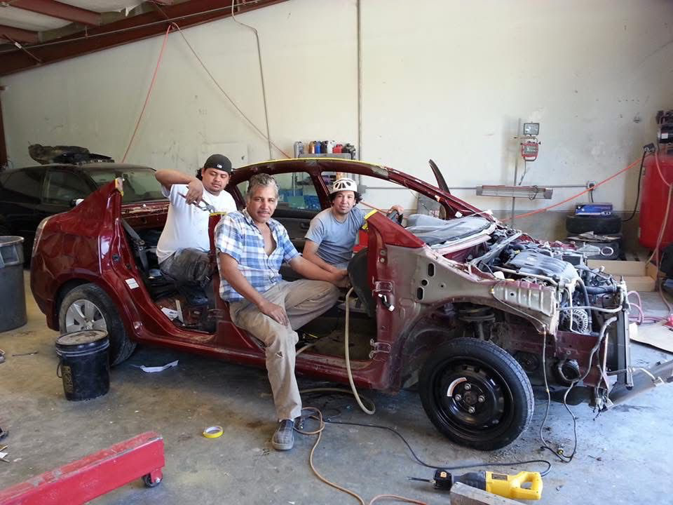 The team together inside the stripped-down red car — a family trade built to last